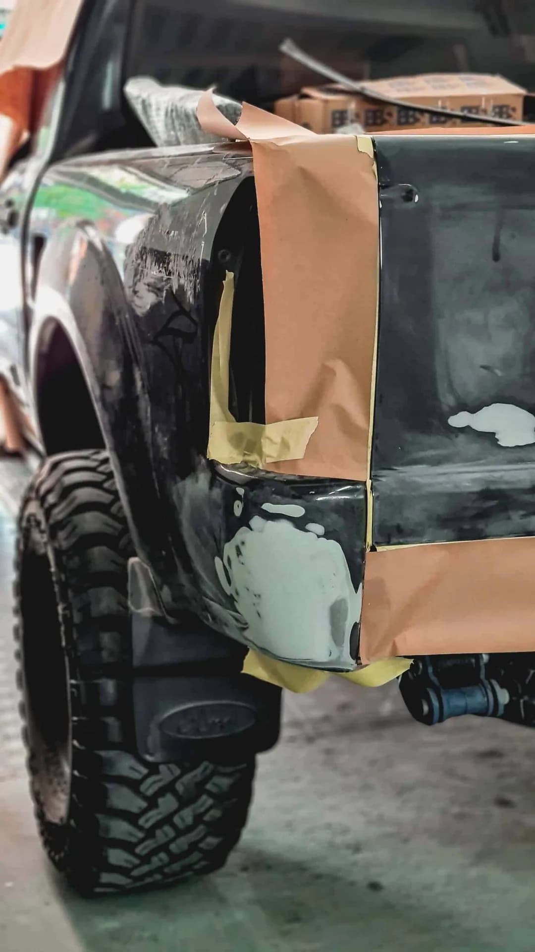 Para-lama de um utilitário lixado e preparado para pintura, com fita de mascaramento